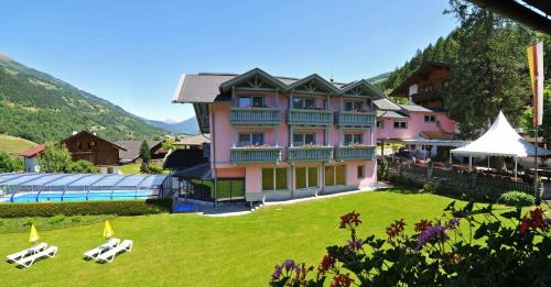 a large pink building with a pool in front of it at Erholungshotel Margarethenbad in Rangersdorf