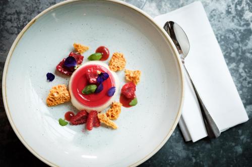 a plate of food with fruit and candy on it at Bel and The Dragon-Odiham in Odiham