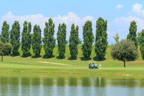 a golf cart on a golf course next to a lake at Parc Hotel in Peschiera del Garda