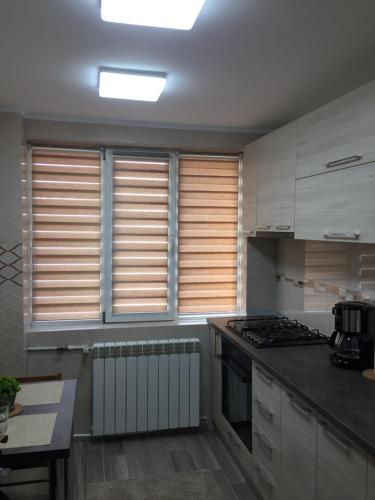 a kitchen with white cabinets and a stove top oven at Roby apartament in Bucharest