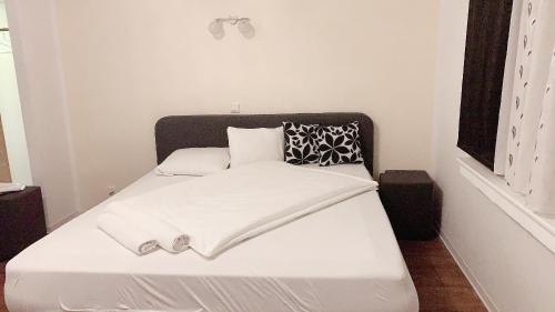 a white bed with a black headboard in a room at Hotel-Restaurant Haus Nattkemper in Hamm
