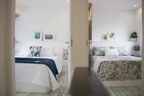 2 camas en una habitación con paredes blancas en Casa d'Avó, en Oporto
