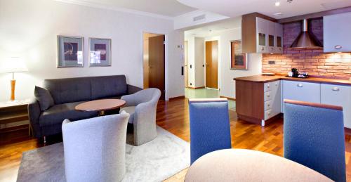 a kitchen and living room with a couch and a table at Holiday Club Tampereen Kehräämö in Tampere