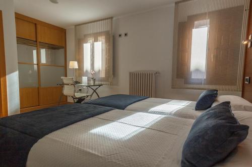 a bedroom with a large bed with blue pillows at Hospederia Seminario Conciliar de San Julián in Cuenca
