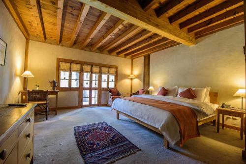 a bedroom with a bed and a desk in a room at Serena Shigar Fort in Shigar