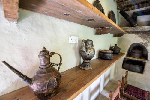 a counter with several vases and an oven on it at Serena Shigar Fort in Shigar