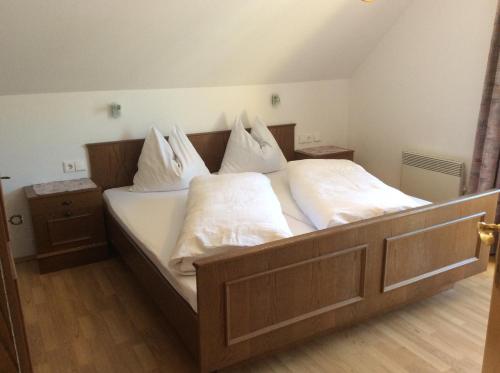 a bedroom with a bed with white sheets and pillows at Apartment Gästehaus Wastian in Weissbriach