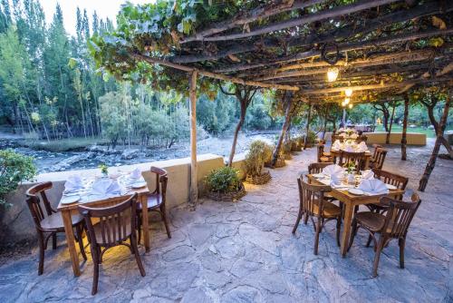 a restaurant with tables and chairs under a pergola at Serena Shigar Fort in Shigar