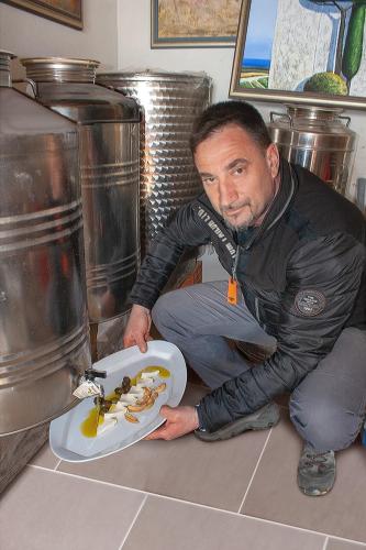 a man sitting on the floor with a plate of food at Rooms Agroturizam Romano in Buje