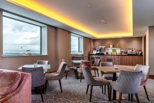 a restaurant with tables and chairs and a kitchen at Crowne Plaza London Heathrow T4 by IHG in Hillingdon