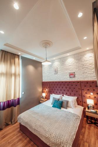 a bedroom with a large bed and a brick wall at Miha Luxury Apartment Card Payment 2BR 50m from Main Square in Belgrade
