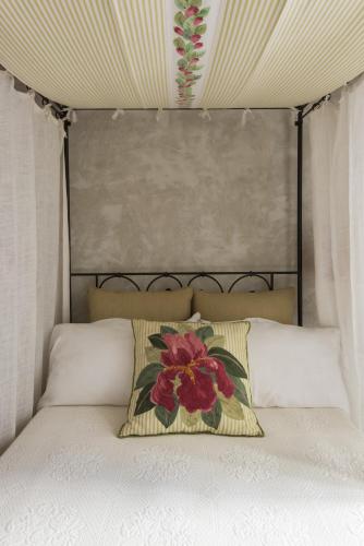 a bed with a flower pillow on top of it at Relais Del Maro in Borgomaro