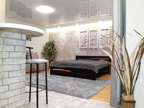 a bedroom with a bed and two bar stools at Apartment - Matusevycha Street 2-11 in Kryvyi Rih