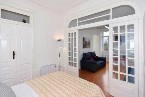 a white bedroom with a bed and a couch at IN PORTO - Santa Catarina Apartment in Porto