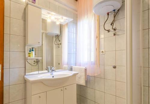 a bathroom with a sink and a mirror at Vila petra in Prizba