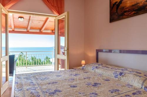 a bedroom with a bed with a view of the ocean at Vila petra in Prizba