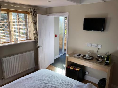 a bedroom with a bed and a television on the wall at Plum Pudding in Abingdon