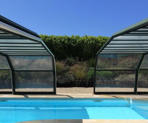 a swimming pool with glass doors on top of it at Hotel Nuit Et Jour - La Maison de Lucile in Cancale