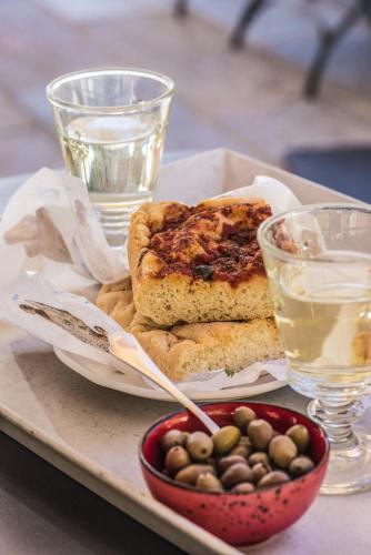 a plate of food with a sandwich and a bowl of olives at Relais Del Maro in Borgomaro