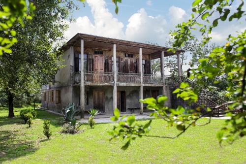 ズグジジにあるDaraselia Family guesthouseの芝生の庭の古家