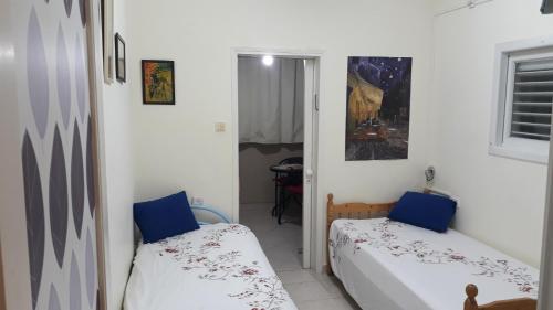 a small room with two beds in a room at Lovely Little Apartment near Beach in Netanya