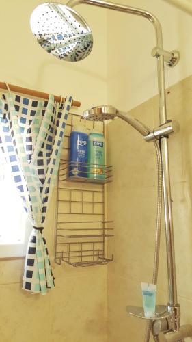 a bathroom with a shower head and a sink at Lovely Little Apartment near Beach in Netanya