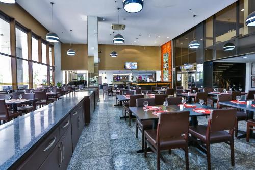 un restaurante con mesas y sillas y un bar en SJ Premium Hotels By Atlantica, en Goiânia