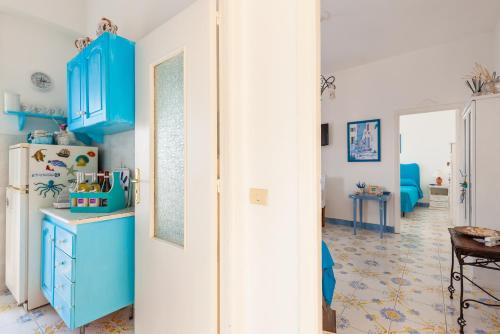 una cucina con armadi blu e frigorifero di Isabella Massalubrense a Massa Lubrense