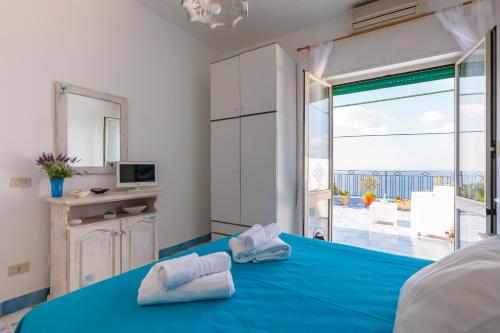a bedroom with a blue bed with a view of the ocean at Isabella Massalubrense in Massa Lubrense