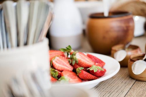 a white bowl of strawberries on a table at Bel and The Dragon-Kingsclere in Kingsclere