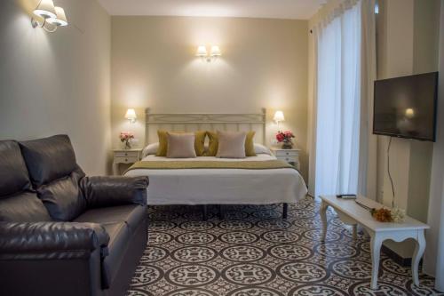 a hotel room with a bed and a couch at Hostal Boutique Casa La Laja in Chiclana de la Frontera