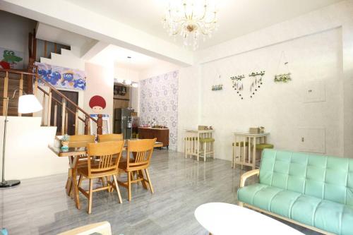 un salon avec un canapé, une table et des chaises dans l'établissement 蘑菇村一津宿囍民宿, à Taïtung