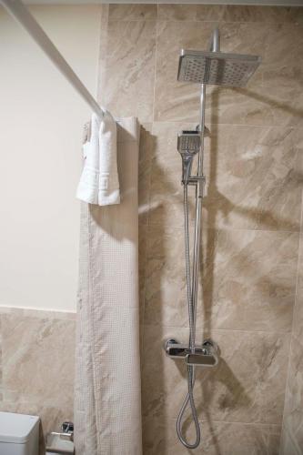 a shower in a bathroom with white boots on a wall at Hostal Boutique Casa La Laja in Chiclana de la Frontera