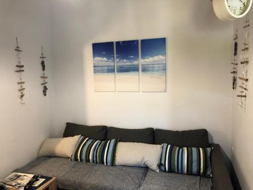 a living room with a couch with two pictures on the wall at BIO Garden Stonehouse in Gonia