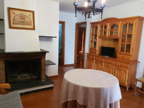 sala de estar con mesa y chimenea en Apartamento Ruta de las Nieves, en Capileira