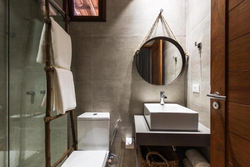 uma casa de banho com um lavatório, um WC e um espelho. em Casa Amarela em Fernando de Noronha