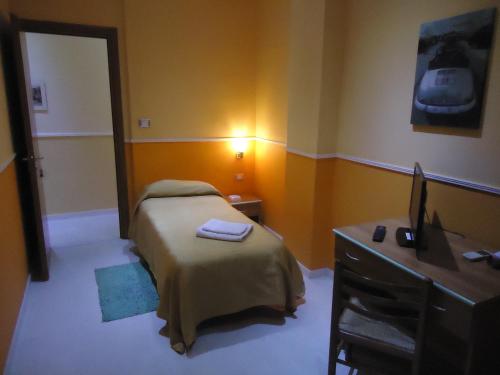 a bedroom with a bed and a desk with a computer at Hotel Gorizia in Catania