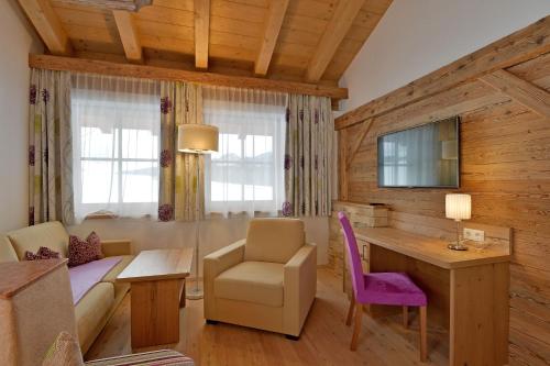 a living room with a couch and a table and a desk at Feriengut Unterhochstätt in Schwendt