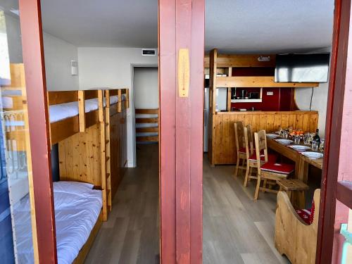 Cette chambre comprend des lits superposés et une table avec un bar. dans l'établissement Arcadien - Appartement les Arcs 1800 - 10 personnes - 3 chambres, à Arc 1800