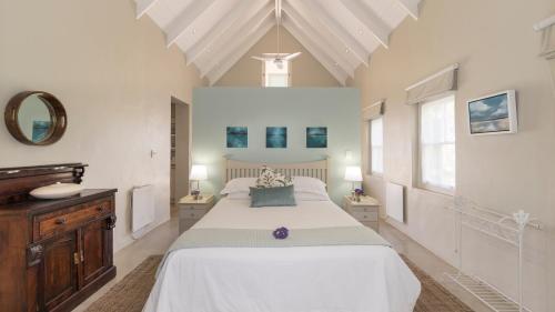 a white bedroom with a large bed and two windows at Maggie's Gift in McGregor