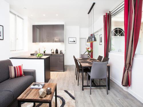 un salon avec une table et une cuisine dans l'établissement Charming 2BR-2BA between le Marais & le Louvre, à Paris