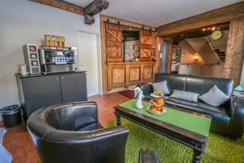 ein Wohnzimmer mit Ledermöbeln und einem Tisch in der Unterkunft Hotel Quellenhof in Grainau