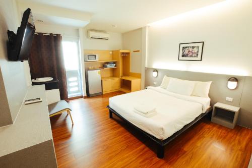 een kleine kamer met een bed en een televisie bij Thaiphiphat house in Bangkok