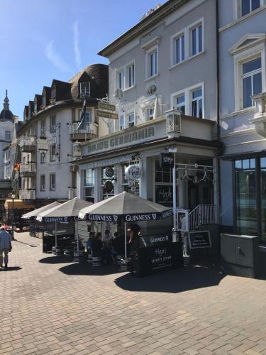 a building with umbrellas on a city street at Hajo´s Germania Lodge & Irish Pub in Rüdesheim am Rhein