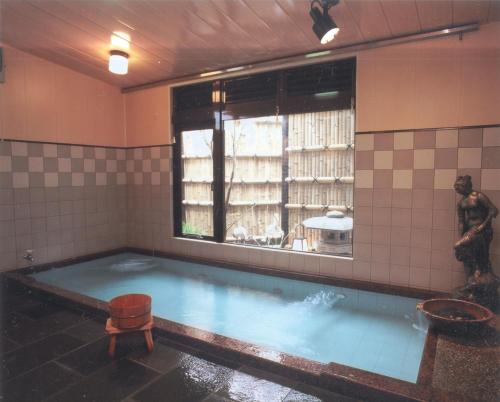 a large pool of water in a room with a statue at Hinodeya in Ito