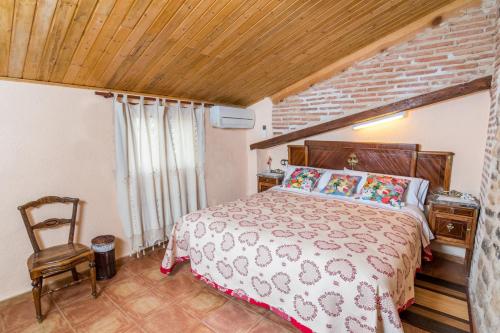 a bedroom with a large bed and a wooden ceiling at Casa rural Rosa in La Fresneda