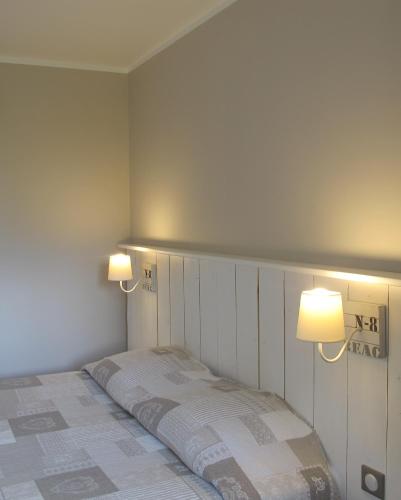 a bedroom with a bed with two lights on it at Hotel Nuit Et Jour - La Maison de Lucile in Cancale