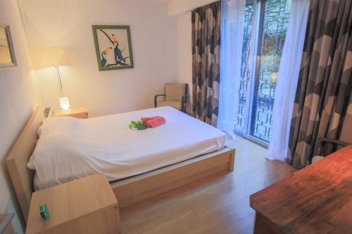 Un dormitorio con una cama blanca con flores. en Jardin Figuiers AP4123 by Riviera Holiday Homes, en Villefranche-sur-Mer