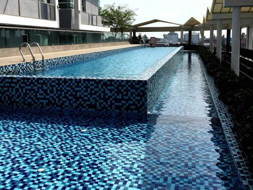 a swimming pool with blue tiles on the side of a building at Excellent Location Premium Studio at Palo 101 Ipoh in Ipoh