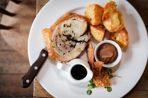 a plate of food with meat and potatoes and sauce at Bel and The Dragon-Kingsclere in Kingsclere